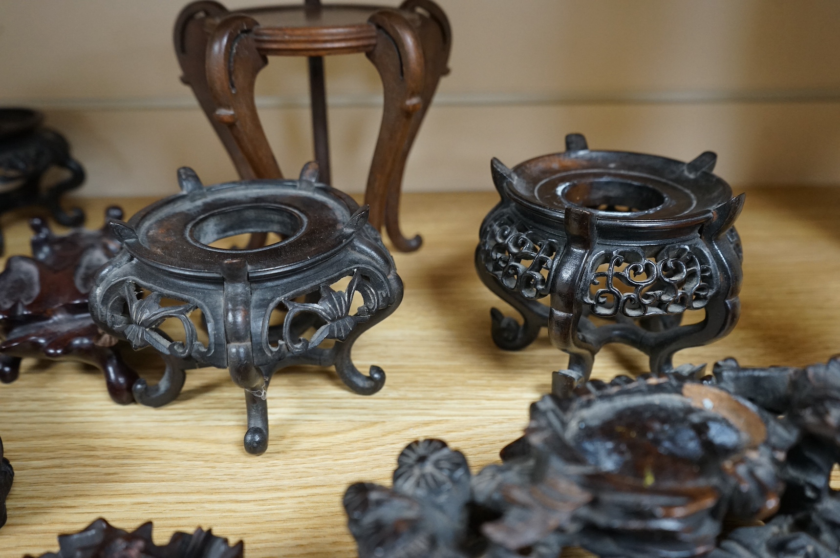 A collection of fifteen Chinese and Japanese carved hardwood stands, tallest 15.5cm. Condition - fair to good